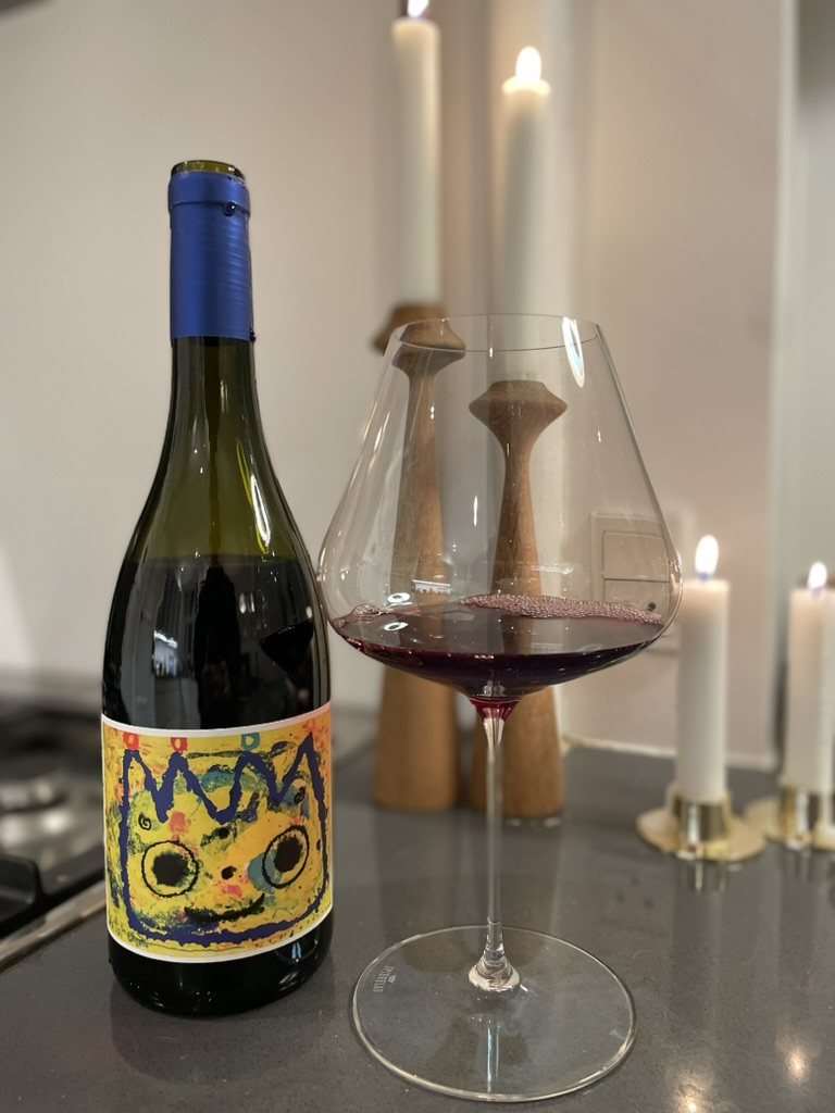 Flaske Arawaru med skænket glas og tændte lys