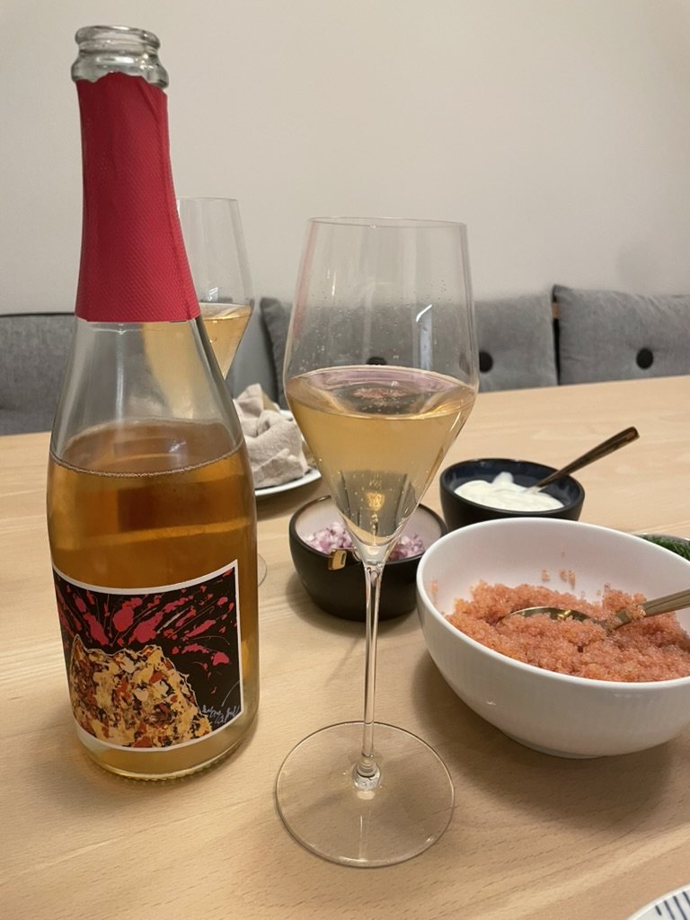 Bakuretsu Cava Rosé skænket op ved siden af en skål rogn og crème fraiche