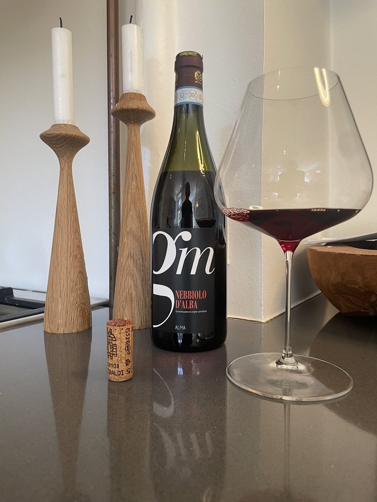 Flaske Nebbiolo d’Alba fra AL-MA med prop og fyldt glas på en køkkenbordplade
